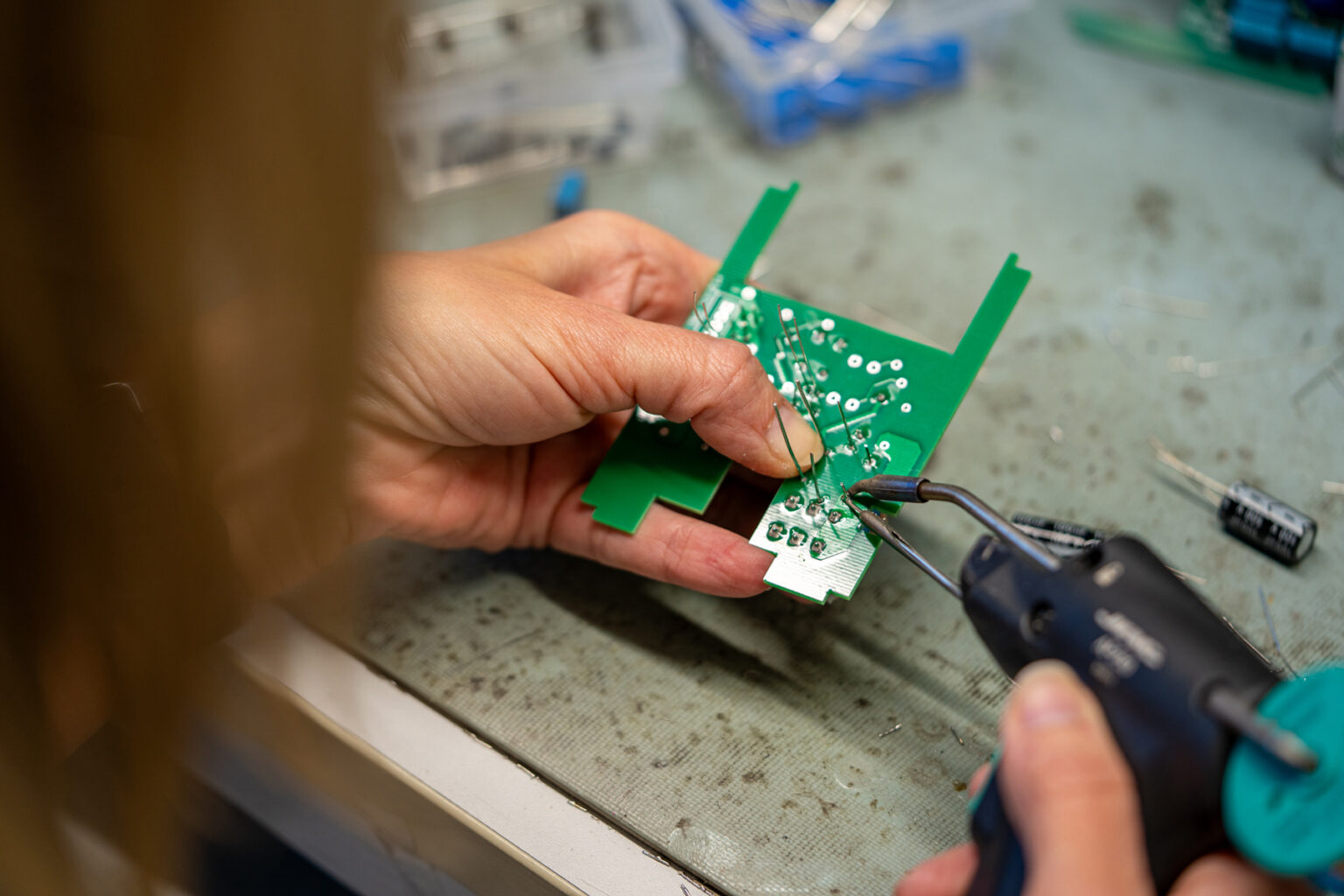 Soudure manuelle de composants électroniques sur un circuit imprimé au sein de l’atelier électricité de l’ETA Le Perron à Liège.